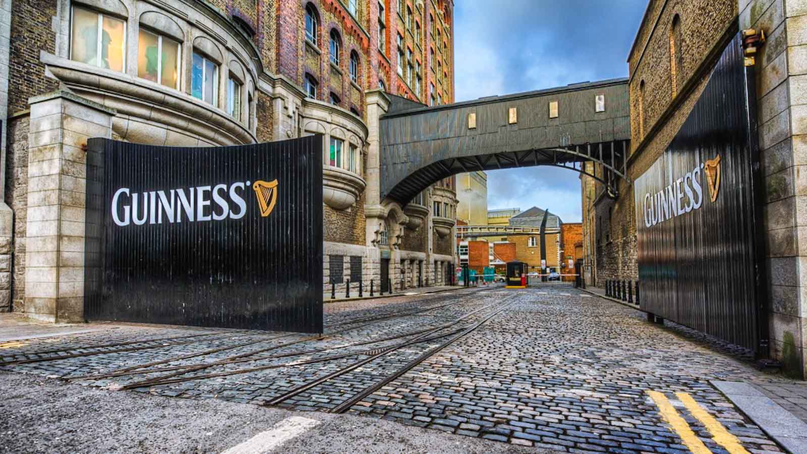 Historic Guinness Storehouse brewery gate in Dublin with black iron doors and gold lettering on a cobblestone street