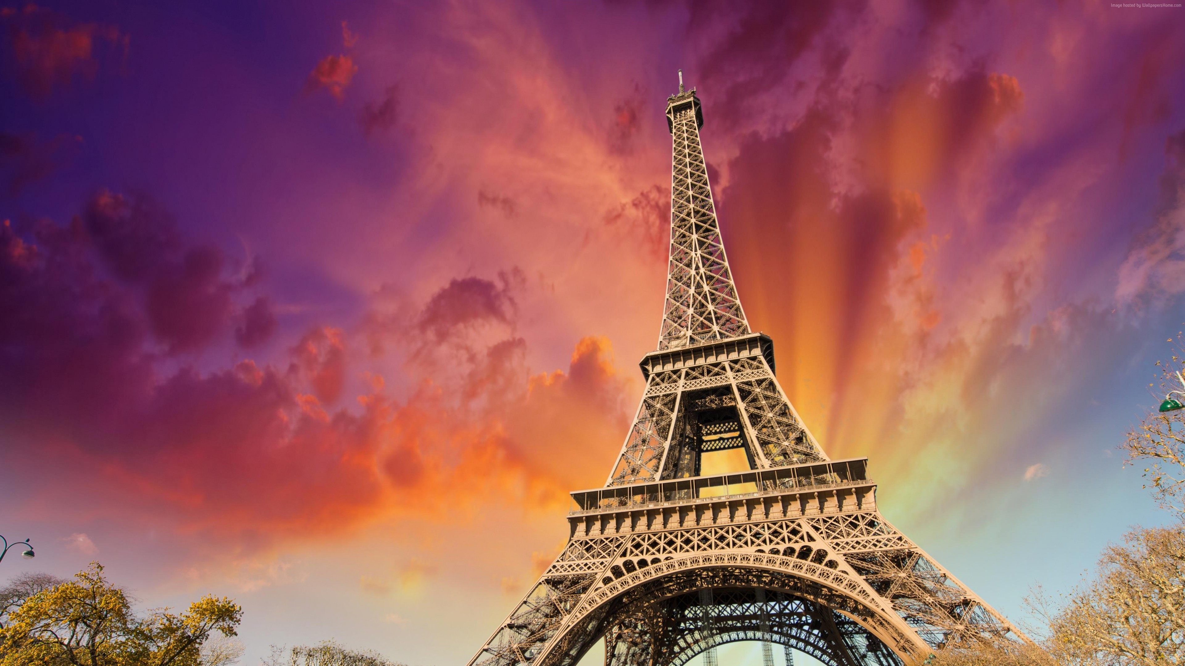Sunset view of the Eiffel Tower glowing against the Parisian skyline