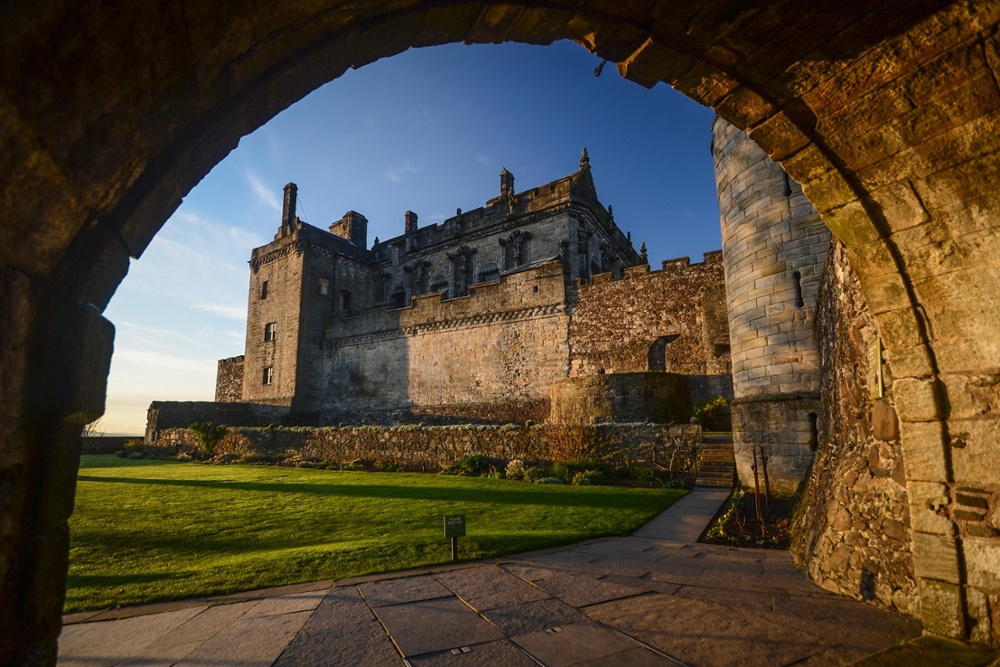 Stirling Castle perched atop a rocky hill, featuring grand stone walls, towers, and sweeping views of the surrounding Scottish landscape.