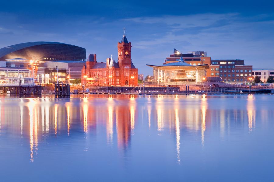 Cardiff Bay cityscape at dusk with illuminated waterfront buildings reflecting on calm water